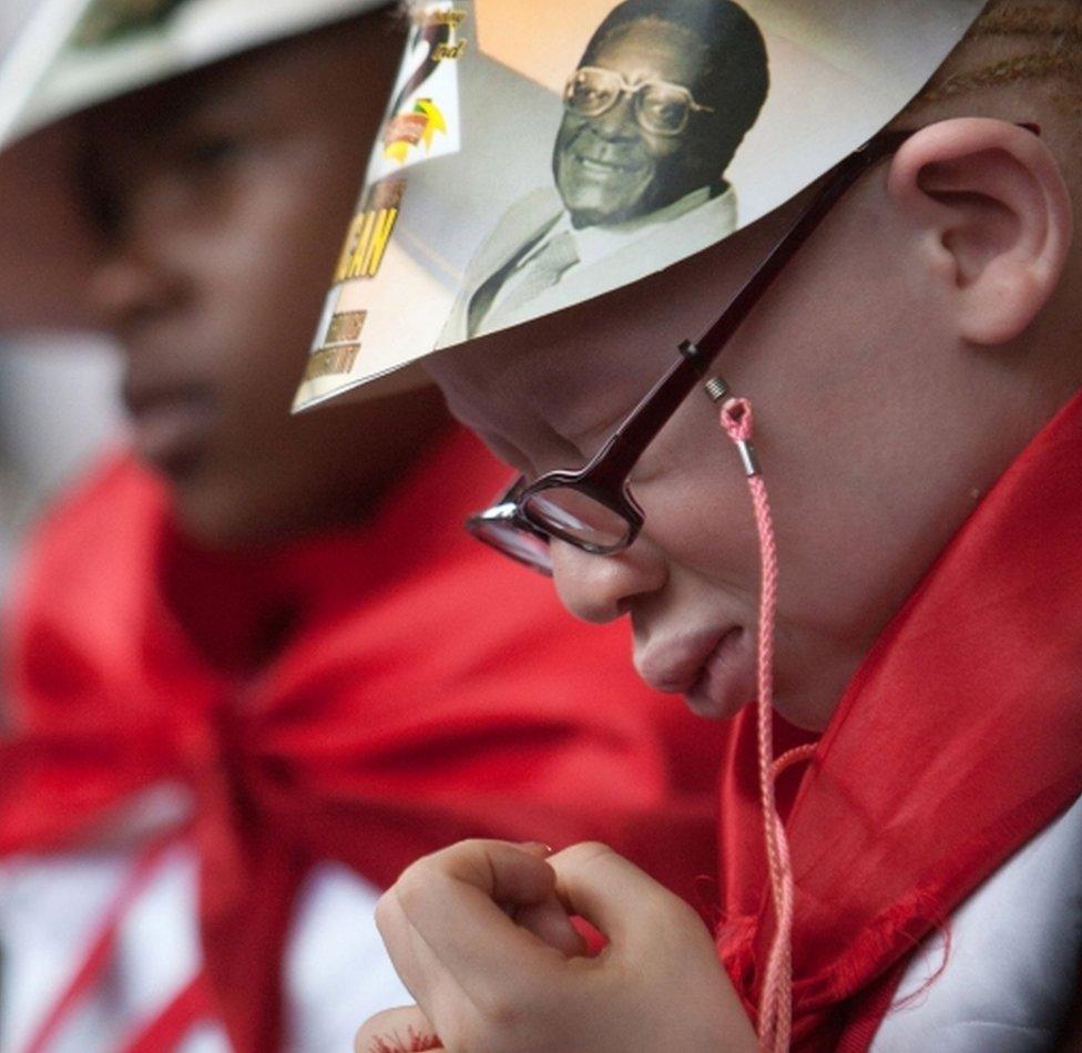 A girl listens to a speech by Zimbabwean President Robert Mugabe during celebrations marking his birthday at the Great Zimbabwe monument in Masvingo on February 27, 2016