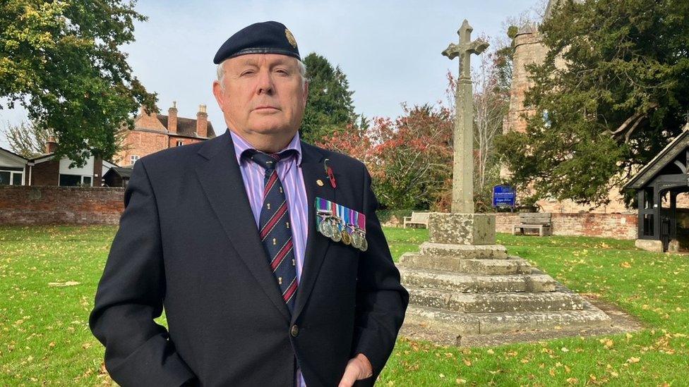 Ian Bruce standing in front of the war memorial at St Mary's Church in Dymock