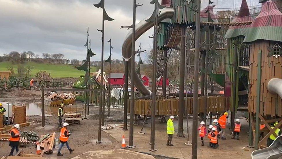 Workers in hard hats with children visiting the site