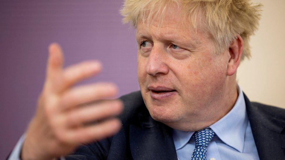 Boris Johnson gestures while speaking during an on-stage event