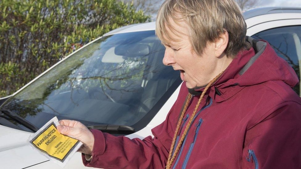 Woman looking shocked and annoyed at parking ticket