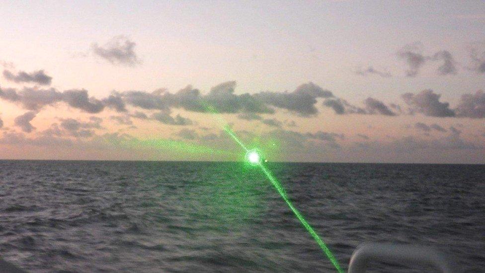 Chinese boat shines green laser on Philippine vessel.