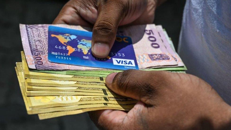 A customer queues at a state bank in Colombo in Sri Lanka.