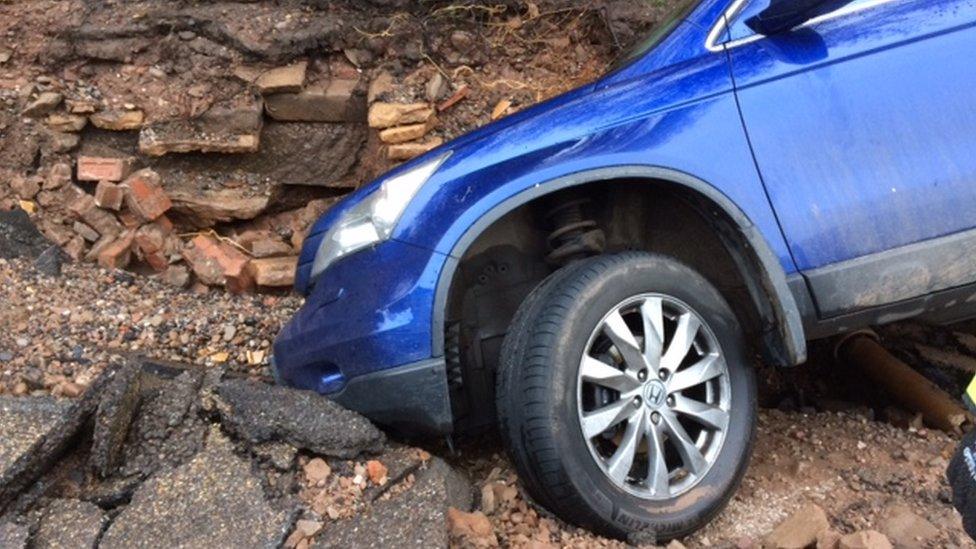 Car in a sinkhole created by a burst water main