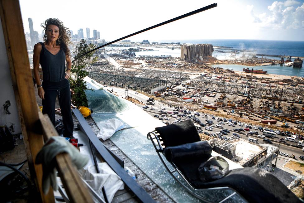 Karina Sukkar stands on the balcony of her damaged apartment overlooking the ravaged port of Beirut