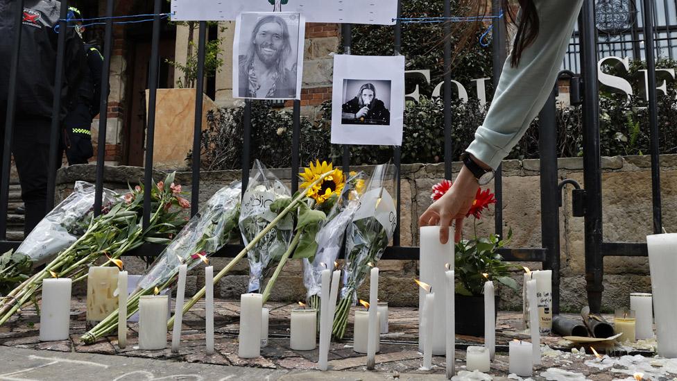 Fans have left candles, flowers and photographs outside the hotel in Bogota