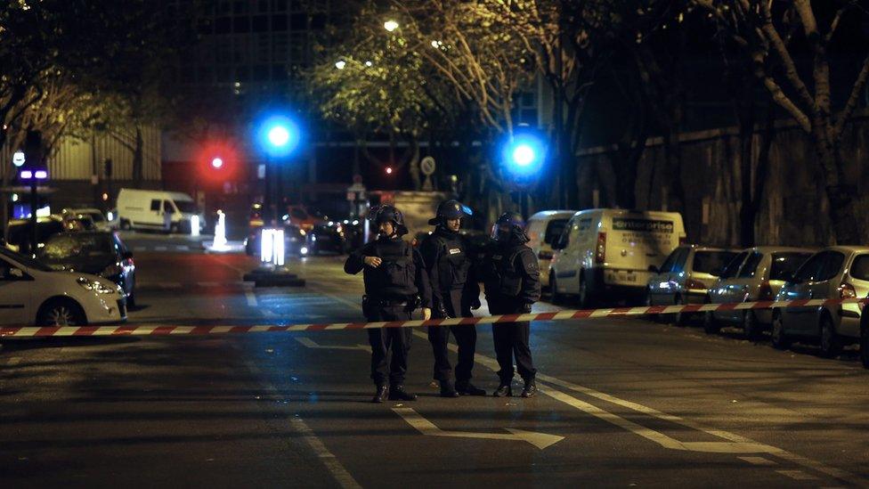 Police in road and tape across street