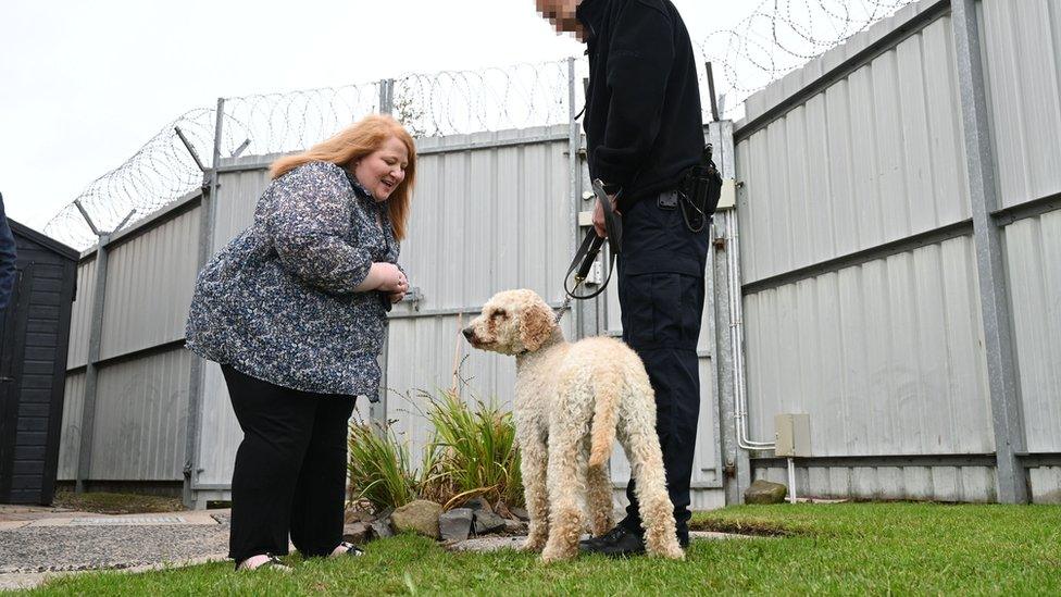 Justice Minister Naomi Long meets one of the Northern Ireland Prison Service dogs and its handler at Maghaberry Prison