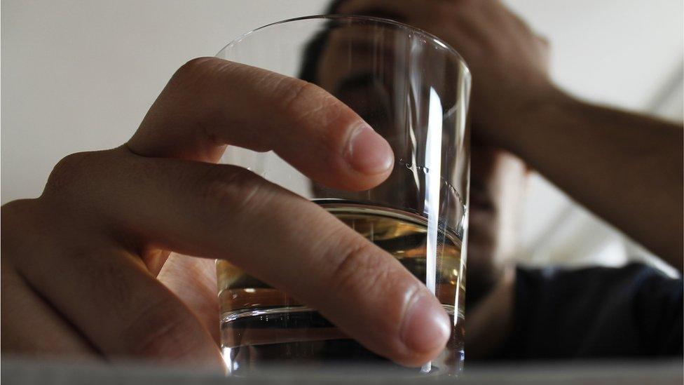 Young man with tumbler of whisky