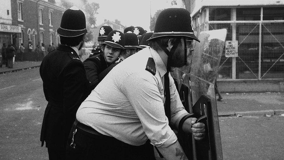 Police holding riot gear