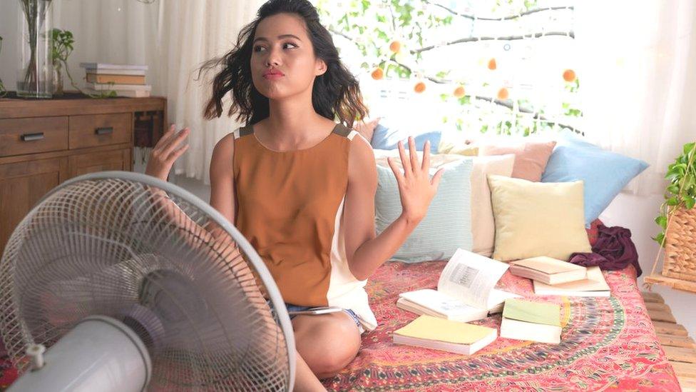 Young woman in front of fan