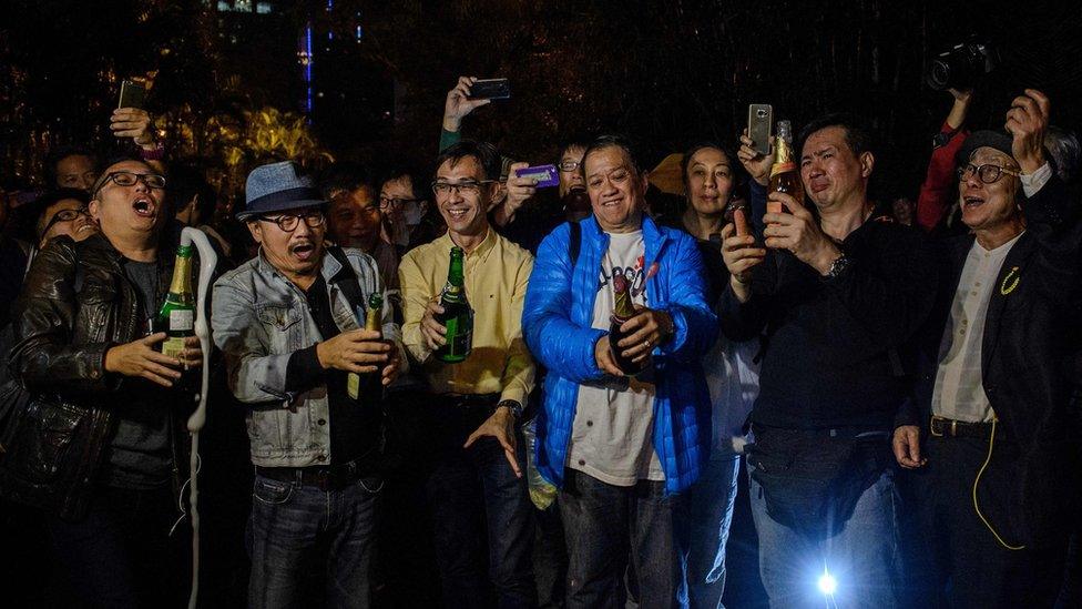 Pro-democracy protesters open champagne bottles to the news that unpopular chief executive Leung Chun-Ying said he would not run for office again in the March vote, during a rally outside his residence in Hong Kong on December 11, 2016,