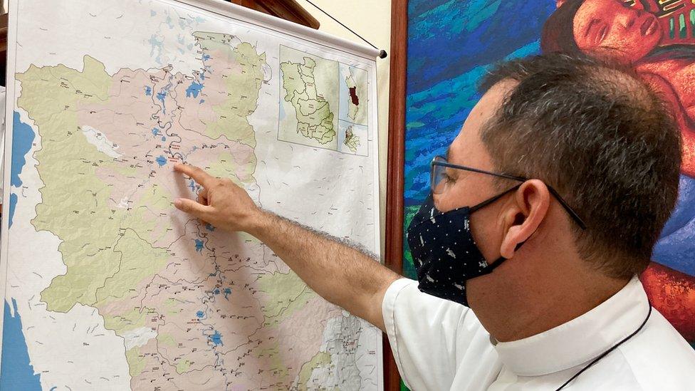 Juan Carlos Barreto points at a map