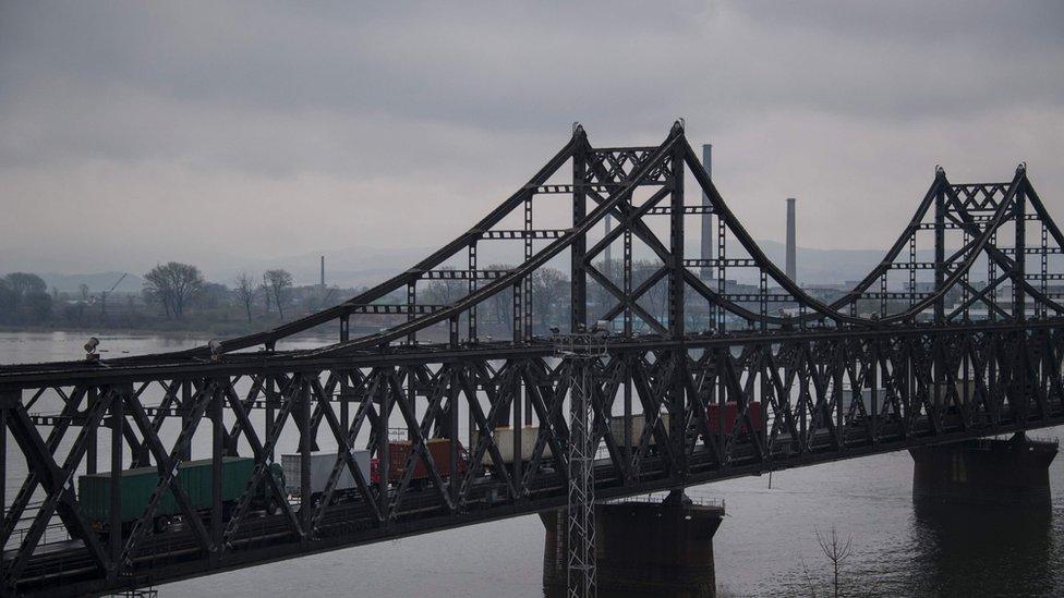 This picture taken on 17 April 2017 shows trucks crossing the Friendship Bridge from the Chinese border city of Dandong to North Korea's Sinuiju over the Yalu river