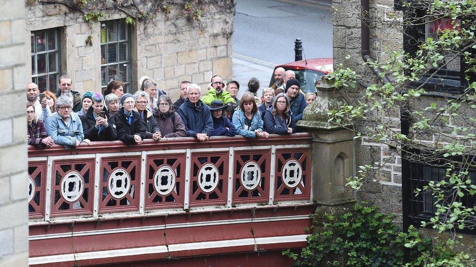 People line a bridge to listen to politicians speak ahead of the 2017 general election