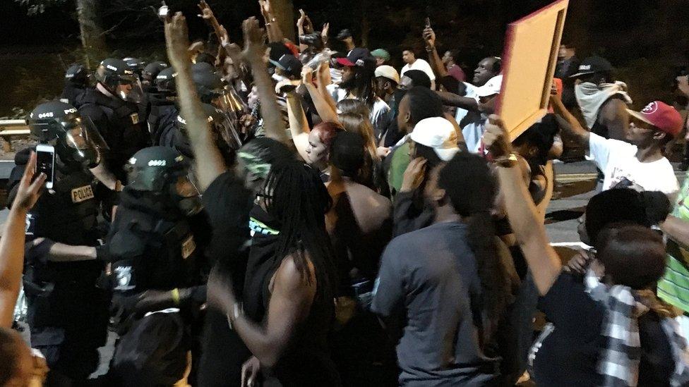 Protestors demonstrate in front of police officers wearing riot gear after police fatally shot Keith Lamont Scott in the parking lot of an apartment complex in Charlotte, North Carolina, U.S. September 20, 2016