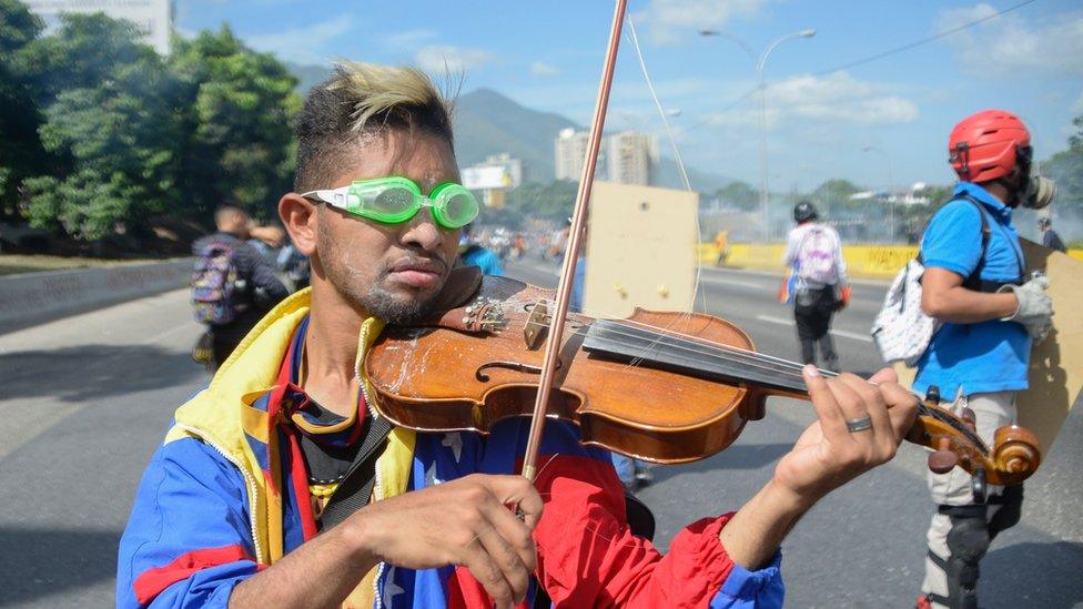 a man wearing swimming goggles and playing the violin, covered in dust