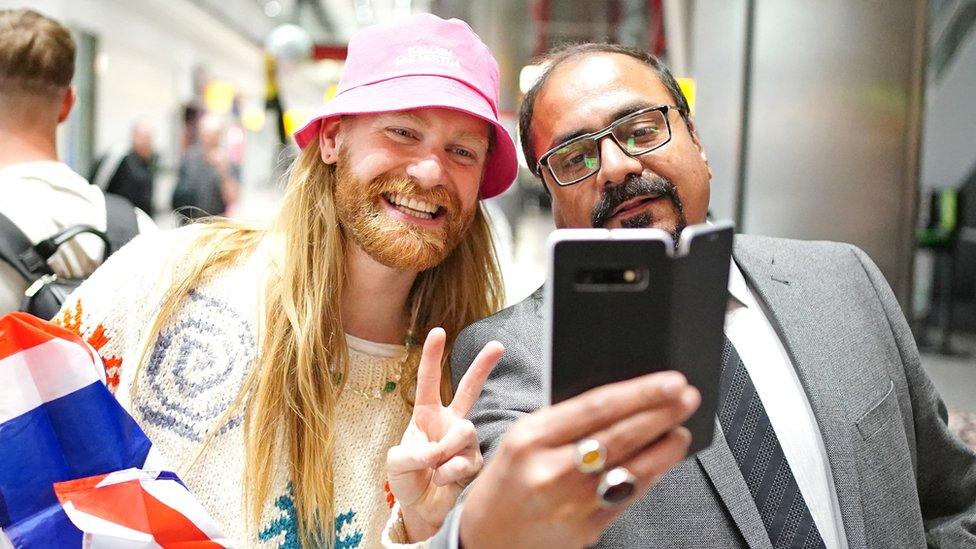 Sam Ryder (left) having a selfie taken after arriving back at Heathrow Airport on Sunday