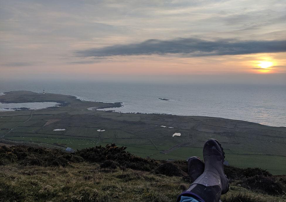 Edrych allan dros yr ynys a'r machlud