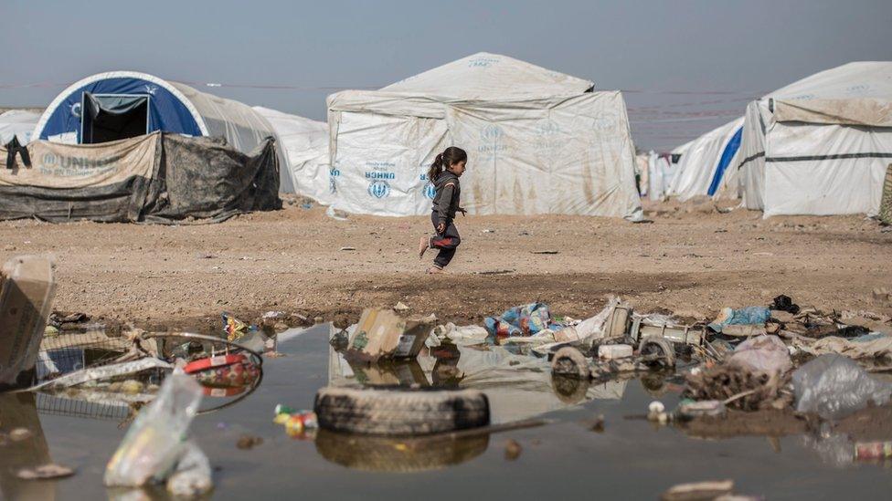 A young Iraqi girl runs barefoot past tents in a camp for internally displaced in the Gazaliya district of Baghdad (3 February 2016)