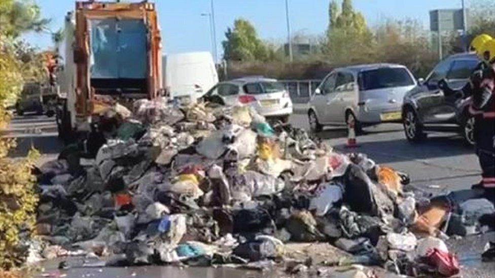 Rubbish bags all over the road, emptied from a bin lorry that caught fire.