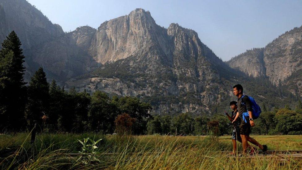 Visitors walk past Columbia Rock in Cook's Meadow in Yosemite Valley, Yosemite National Park