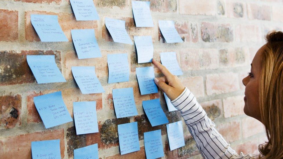 Woman looking at post-it notes