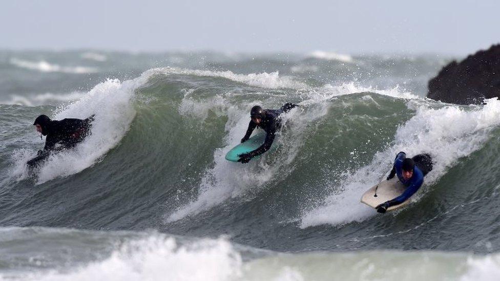 Body boarders ride the stormy waves at Broad Haven, Pembrokeshire, Wales