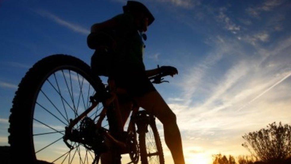 A cyclist stops on his bike