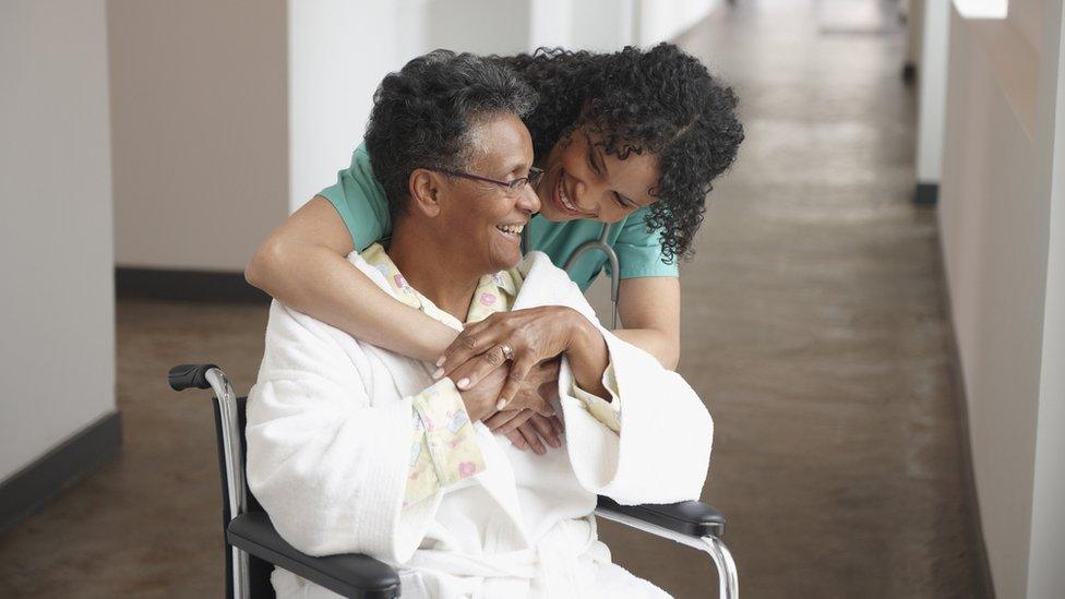 Elderly woman and health professional. Both smiling.