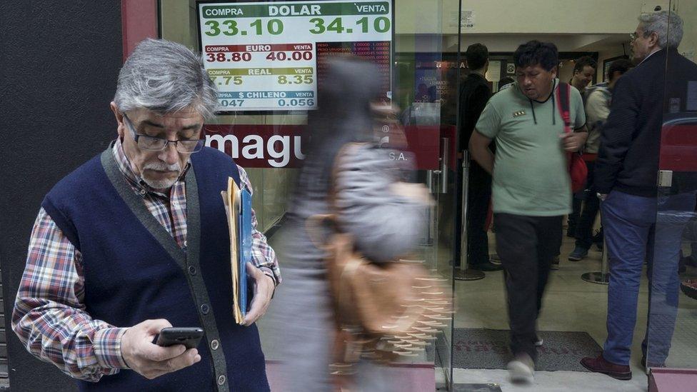 Currency exchange values are displayed in the buy-sell board of a bureau de exchange in Buenos Aires, on August 29, 2018.