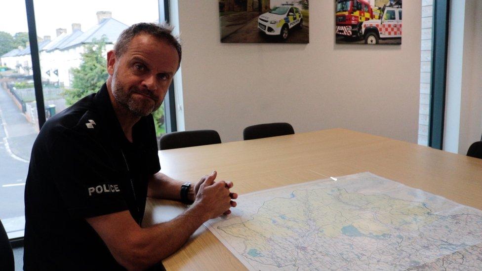 Insp Ed Turner sitting at a desk with a map on it