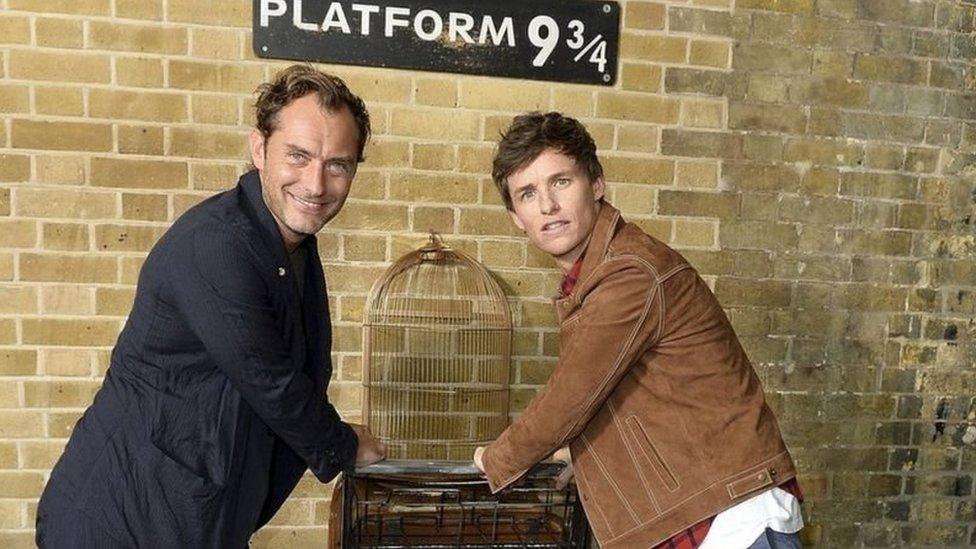 Jude Law and Eddie Redmayne pose at Platform 9 and 3/4 at London King's Cross station