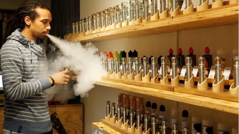 An employee demonstrates vaping