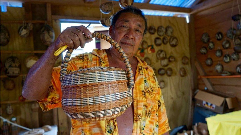 Willard Bruney shows off a basked a has woven