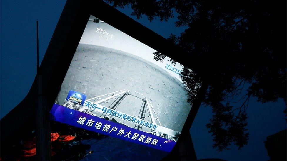 A TV screen showing an image of Mars taken by Chinese Mars rover Zhurong