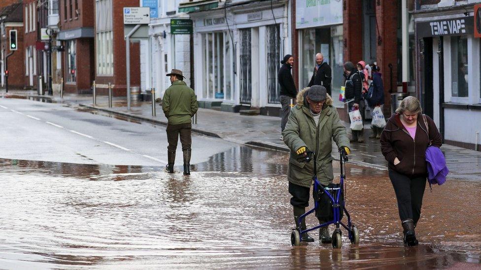 People wade through flood water in Tenbury Wells, Worcestershire