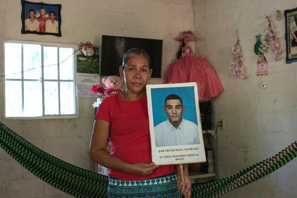 Marcela Alvarado holds a placard with a photo of her jailed son