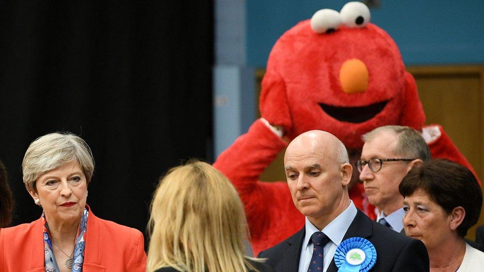 Elmo looms behind Prime Minister Theresa May at the Magnet Leisure Centre in Maidenhead, after she held her seat.