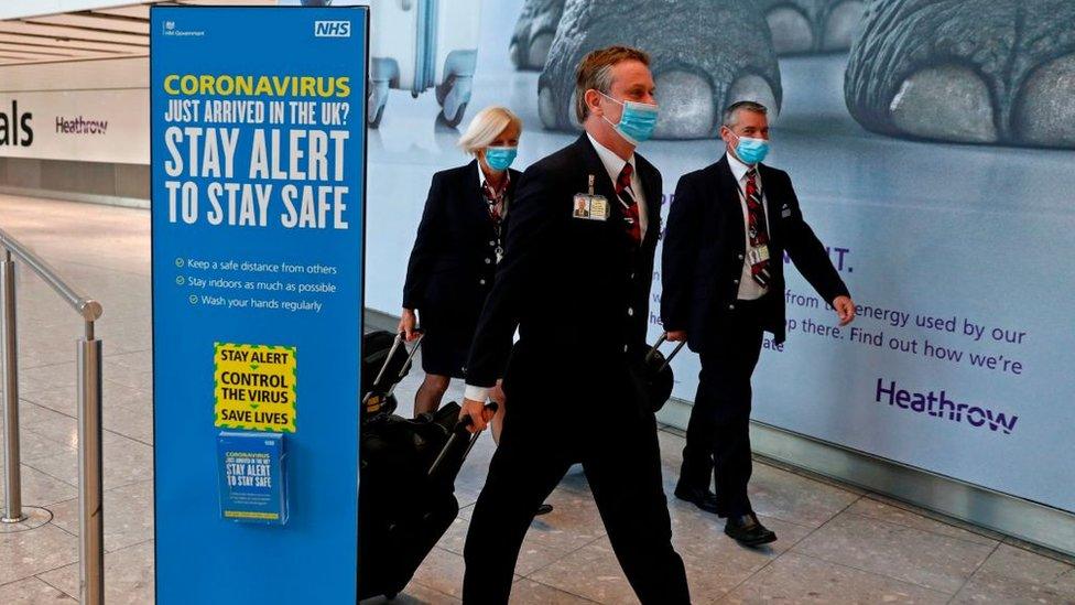 British Airways pilots wearing masks walk through Heathrow Airport