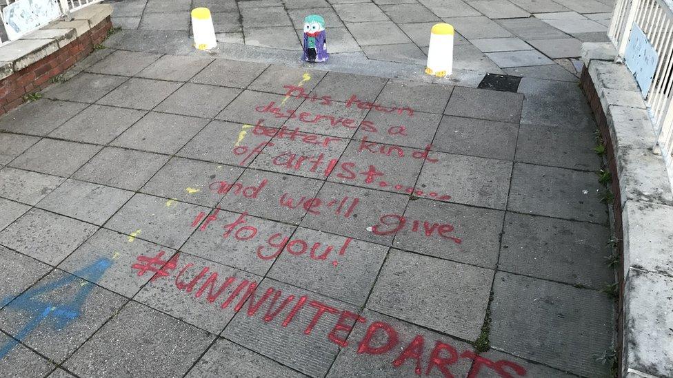 The repainted bollards and graffiti on pavement