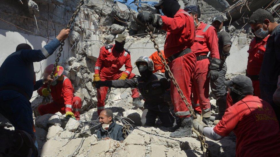 Iraqi firefighters look for bodies buried under the rubble after a reported air strike in western Mosul (27 March 2017)