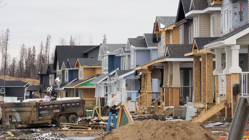 Homes are being rebuilt in Fort McMurray one year after a devastating fire, April 18, 2017 in Fort McMurray, Canada. A few late-season snowflakes flutter over Fort McMurray, their whiteness contrasting against surrounding forests blackened one year ago by the most destructive wildfire in Canadian history