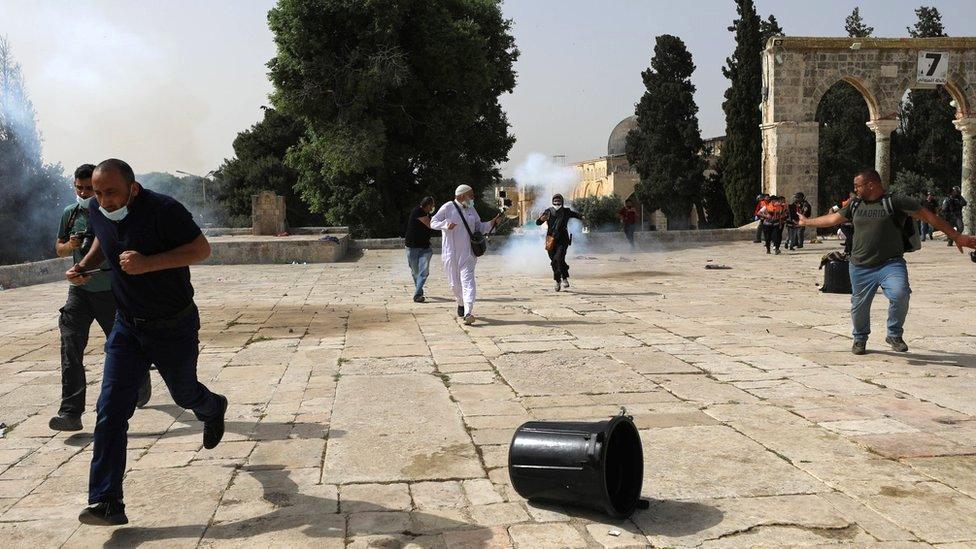 Palestinians run away after Israeli police fire stun grenades during clashes around the al-Aqsa mosque, in occupied East Jerusalem (10 May 2021)