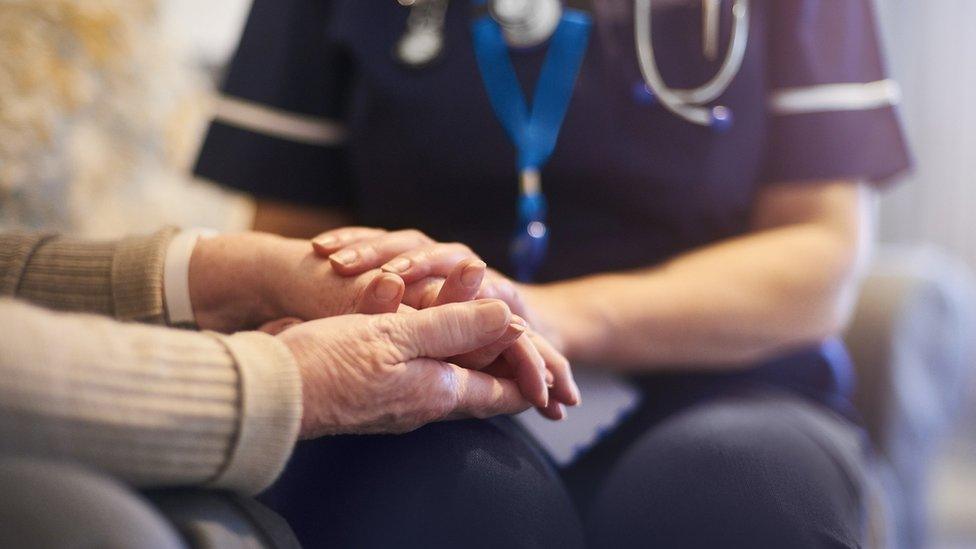 Stock image of a nurse looking after an elderly man