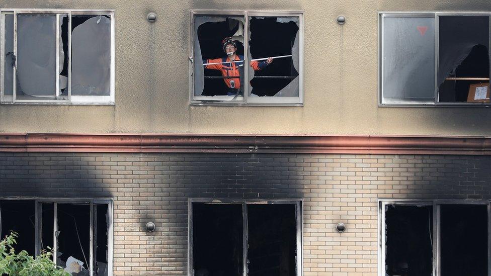 A firefighter inspects the interior of the torched Kyoto Animation building in Kyoto