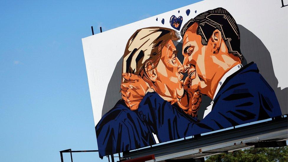 A billboard erected in advance of the Republican National Convention depicts U.S. Republican presidential candidate Donald Trump kissing former presidential candidate Sen. Ted Cruz - July 2016