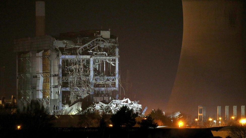 Part of a collapsed building is illuminated by the emergency services as they work at the decommissioned Didcot A power station