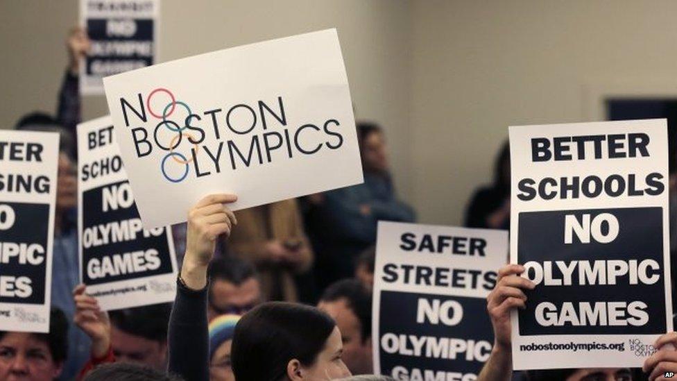 People hold up placards against the Olympic Games coming to Boston, during the first public forum regarding the city's 2024 Olympic bid, in Boston. 5 February 2015