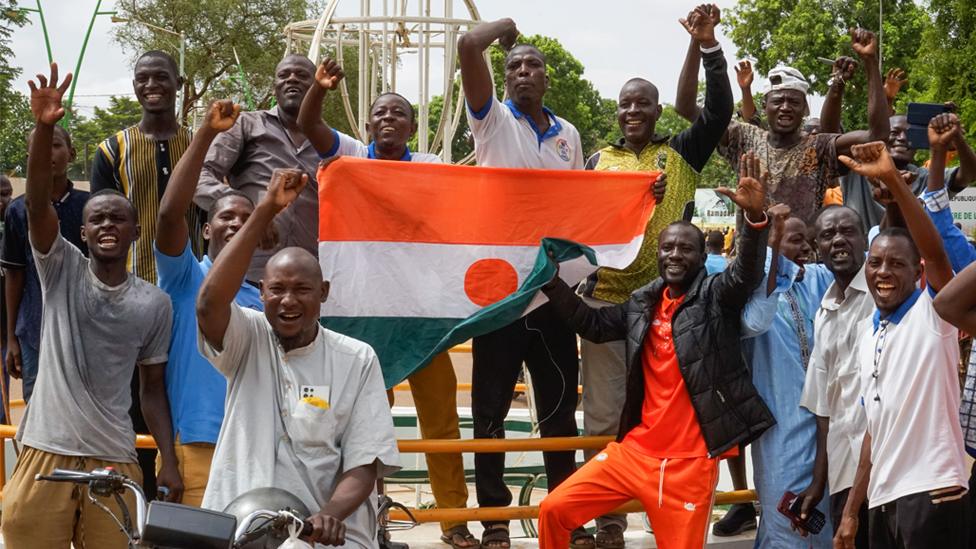 Coup supporters display the flag of Niger during a rally in Niamey, Niger